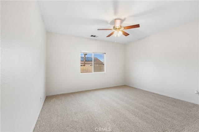 empty room featuring ceiling fan and carpet