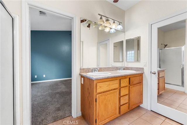 bathroom featuring vanity, a shower with shower door, and tile patterned flooring