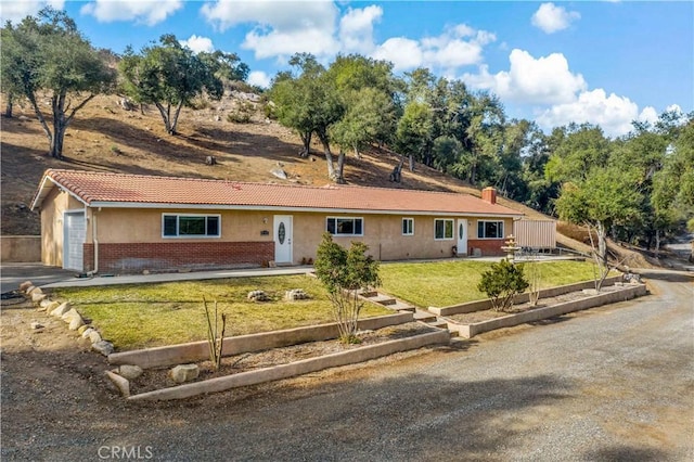 ranch-style house with a garage and a front lawn