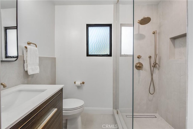 bathroom featuring vanity, toilet, tile patterned flooring, and a tile shower