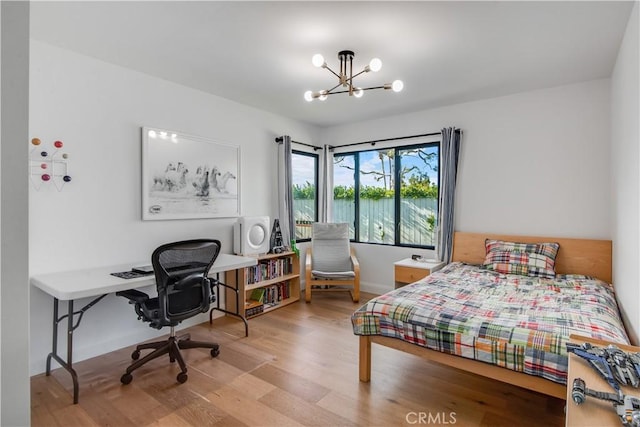 bedroom featuring wood-type flooring and a chandelier