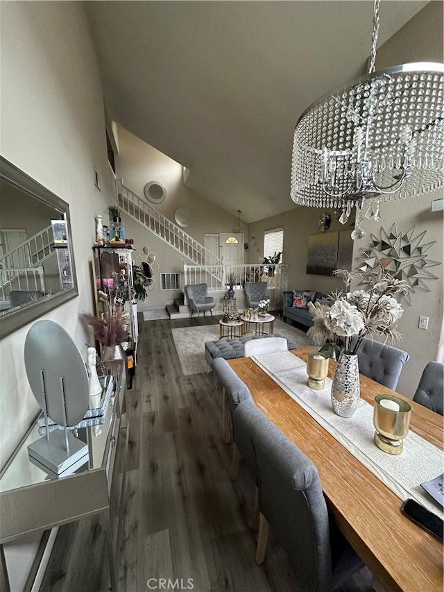 dining area with vaulted ceiling, hardwood / wood-style floors, and an inviting chandelier