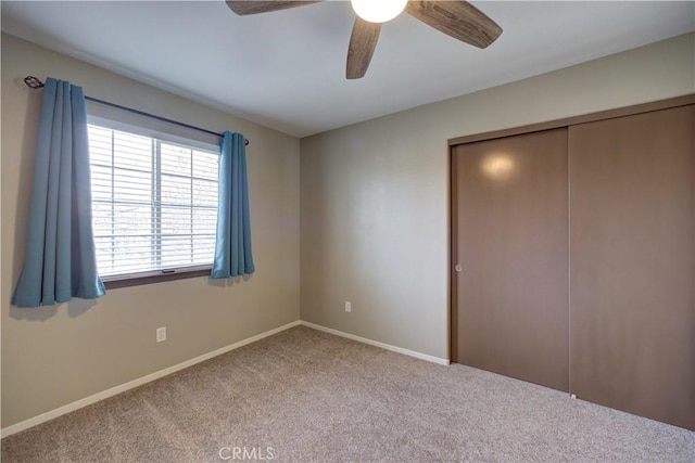 unfurnished bedroom with light colored carpet, ceiling fan, and a closet