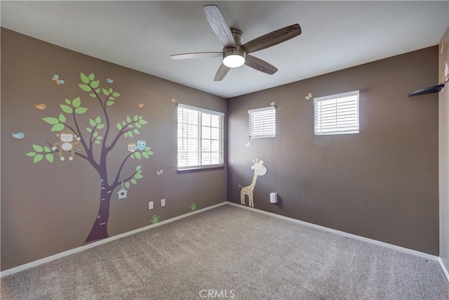 unfurnished room with plenty of natural light, carpet flooring, and ceiling fan