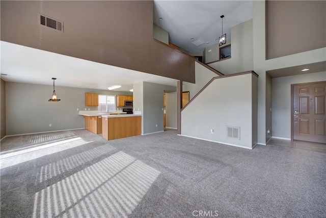 unfurnished living room with light colored carpet and a high ceiling