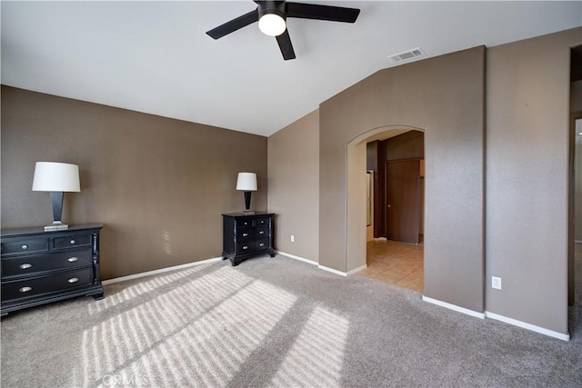 unfurnished bedroom with vaulted ceiling, light colored carpet, and ceiling fan