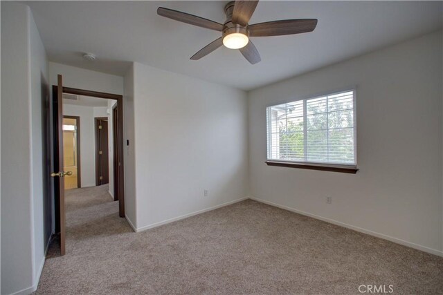 carpeted empty room with baseboards and ceiling fan