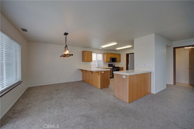 kitchen featuring a peninsula, light colored carpet, appliances with stainless steel finishes, and visible vents