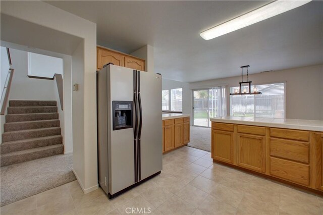 kitchen with decorative light fixtures, light colored carpet, light tile patterned floors, refrigerator with ice dispenser, and tile counters