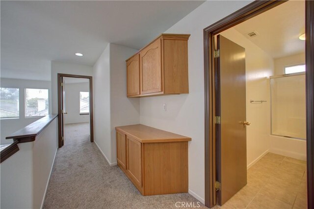 hallway with a healthy amount of sunlight, baseboards, recessed lighting, and visible vents