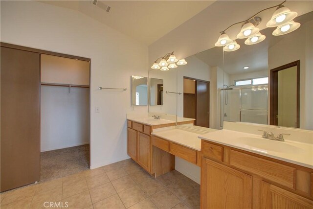 bathroom with visible vents, a shower with shower door, vanity, a spacious closet, and lofted ceiling