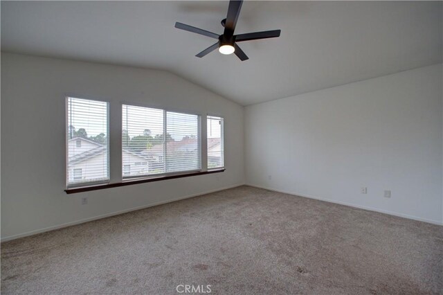carpeted spare room with baseboards, a ceiling fan, and lofted ceiling
