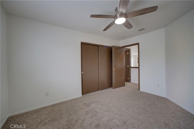 unfurnished bedroom featuring carpet floors, visible vents, and a closet