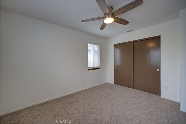 unfurnished bedroom with a closet, baseboards, carpet flooring, and visible vents