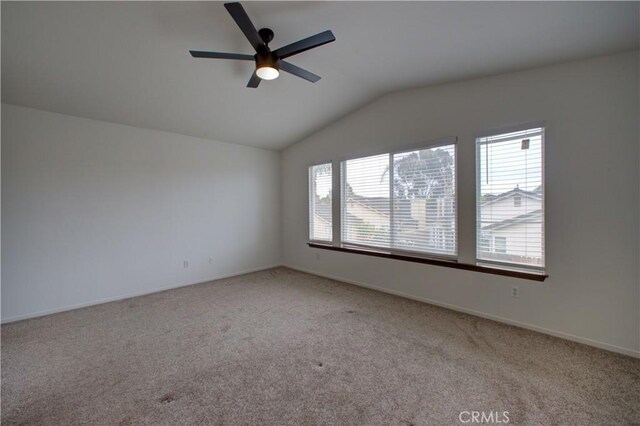 spare room with light colored carpet, a ceiling fan, baseboards, and vaulted ceiling