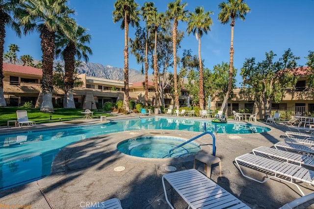 view of swimming pool with a mountain view and a community hot tub