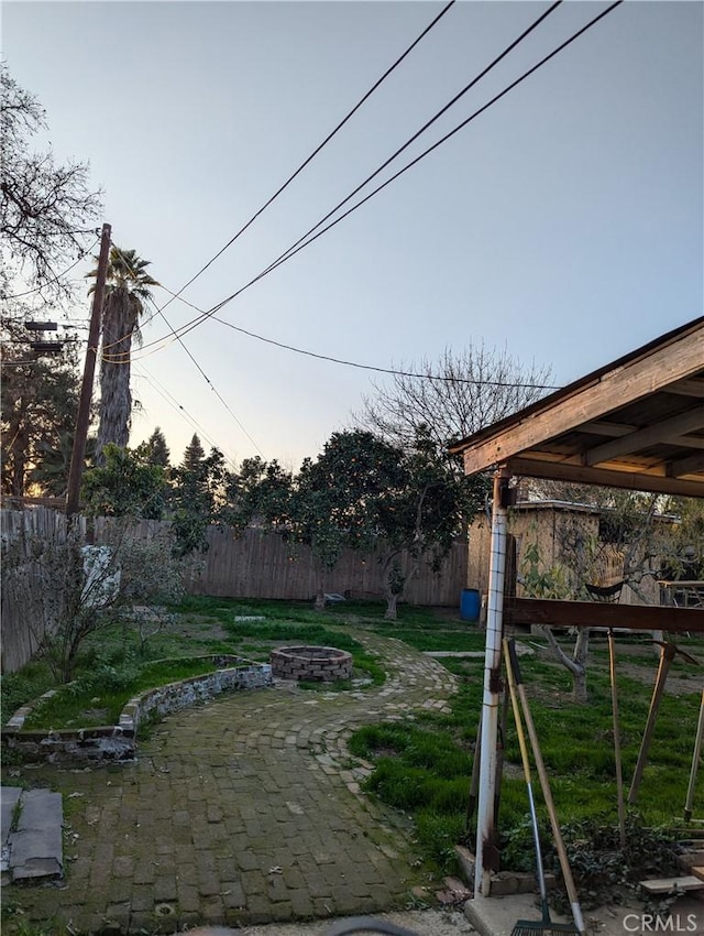 yard at dusk with a patio area and an outdoor fire pit