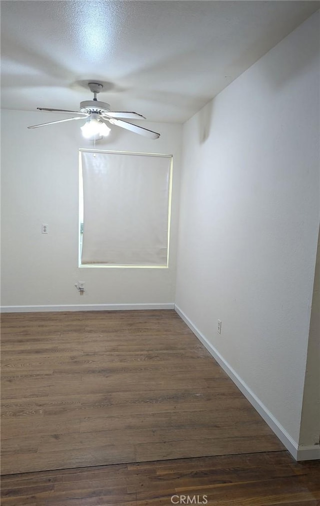 empty room with ceiling fan and dark hardwood / wood-style flooring