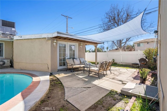 view of patio / terrace featuring outdoor lounge area, cooling unit, ac unit, a fenced in pool, and french doors