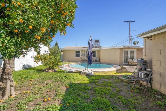 view of yard with a fenced in pool and french doors