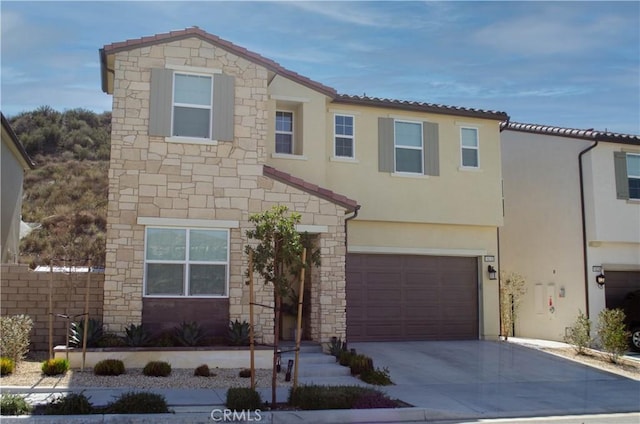 view of front of property featuring a garage, stone siding, driveway, and stucco siding