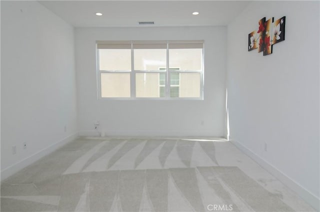 carpeted spare room featuring recessed lighting, visible vents, and baseboards