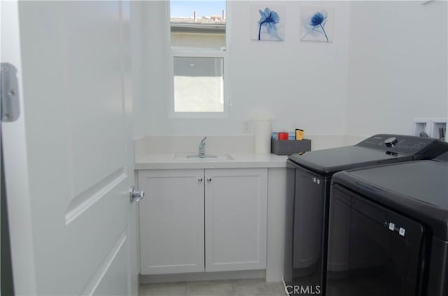 washroom featuring cabinet space, a sink, and washing machine and clothes dryer