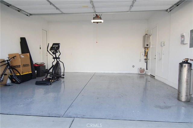 garage featuring water heater, electric panel, and a garage door opener