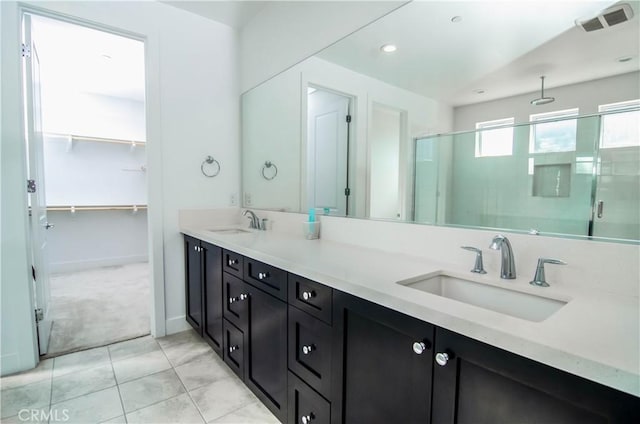 bathroom featuring a stall shower, visible vents, a sink, and double vanity