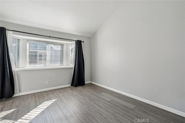 unfurnished room featuring hardwood / wood-style flooring and vaulted ceiling