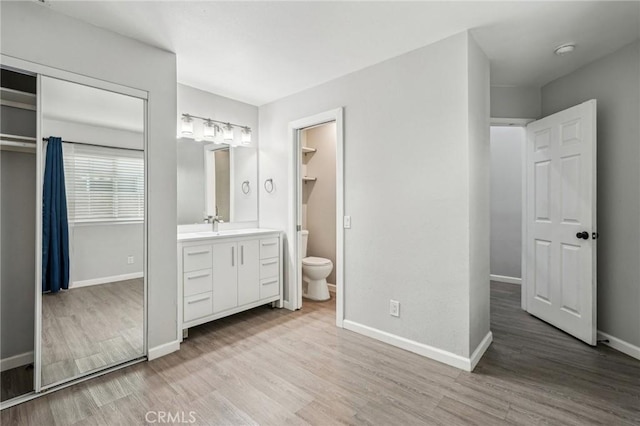 unfurnished bedroom featuring light hardwood / wood-style floors, a closet, and ensuite bathroom