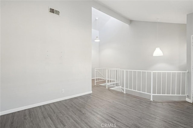 unfurnished room with wood-type flooring and vaulted ceiling with beams