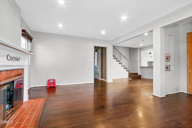 living room with a tiled fireplace and dark hardwood / wood-style floors