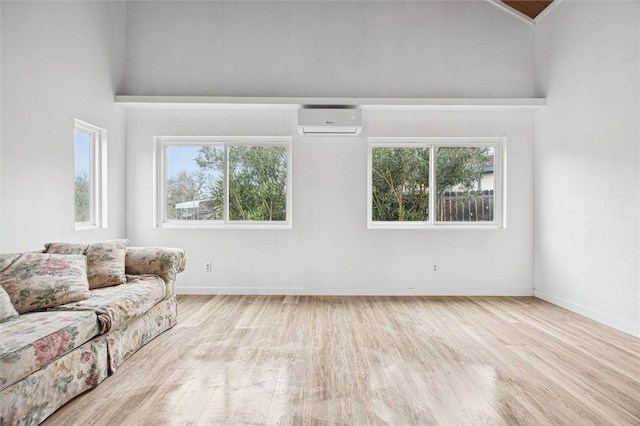 unfurnished living room featuring light wood-type flooring and a wall mounted AC