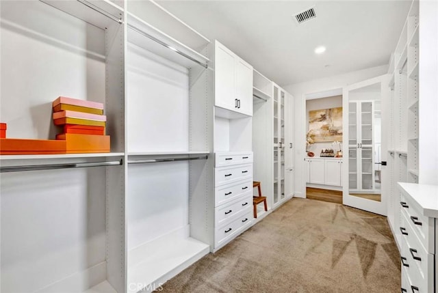 spacious closet featuring light colored carpet