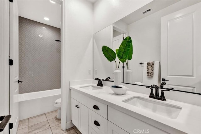 full bathroom with tiled shower / bath, vanity, toilet, and tile patterned flooring