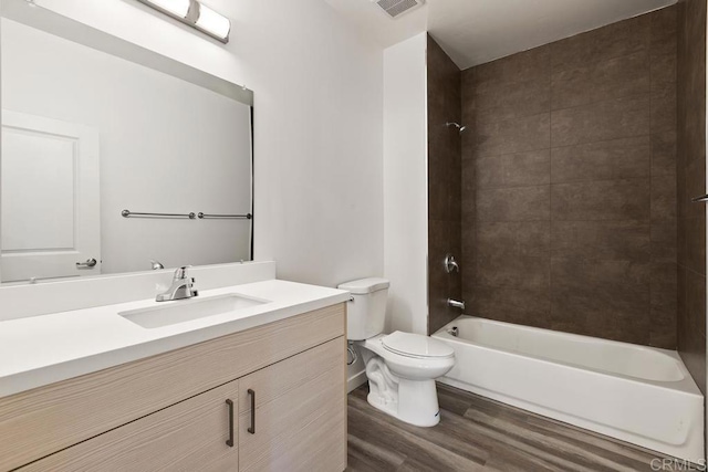 full bathroom featuring tiled shower / bath, wood-type flooring, toilet, and vanity