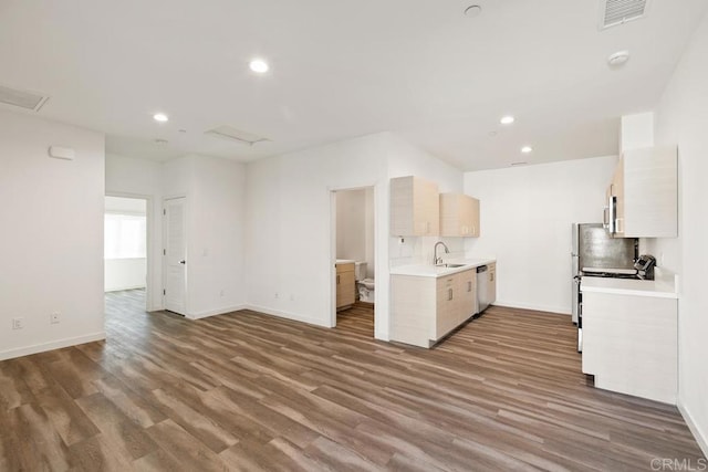 kitchen with hardwood / wood-style flooring, appliances with stainless steel finishes, sink, and tasteful backsplash