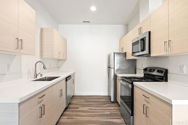 kitchen with light brown cabinetry, sink, dark wood-type flooring, and stainless steel appliances
