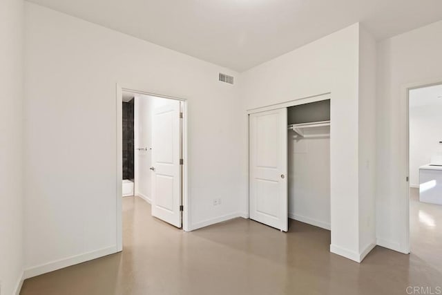 unfurnished bedroom with concrete flooring and a closet