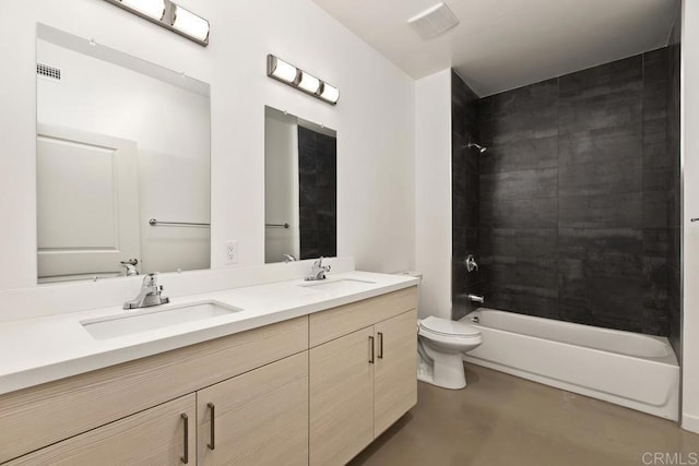 full bathroom with vanity, tiled shower / bath combo, concrete floors, and toilet