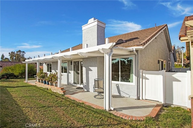 rear view of house featuring a pergola, a lawn, and a patio