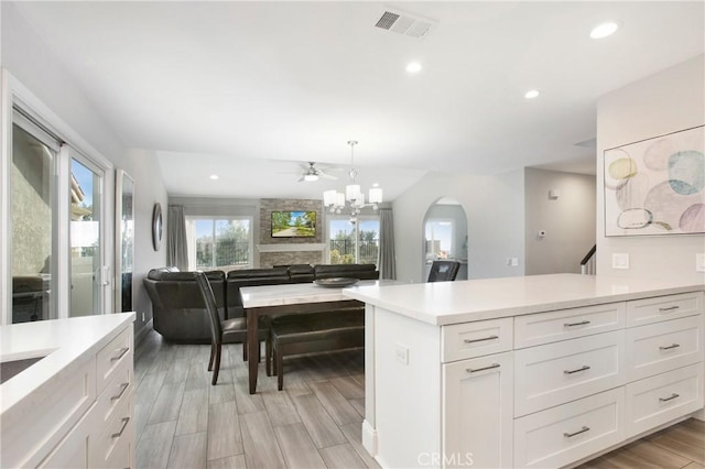 kitchen featuring hanging light fixtures, a notable chandelier, white cabinets, and light wood-type flooring