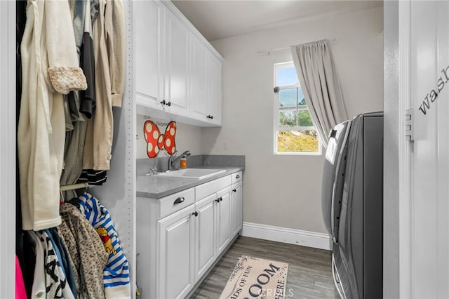 laundry area with dark hardwood / wood-style flooring, sink, washer / clothes dryer, and cabinets