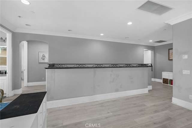 interior space with crown molding, white cabinets, and light hardwood / wood-style flooring