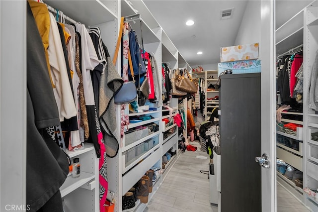 spacious closet with light hardwood / wood-style flooring