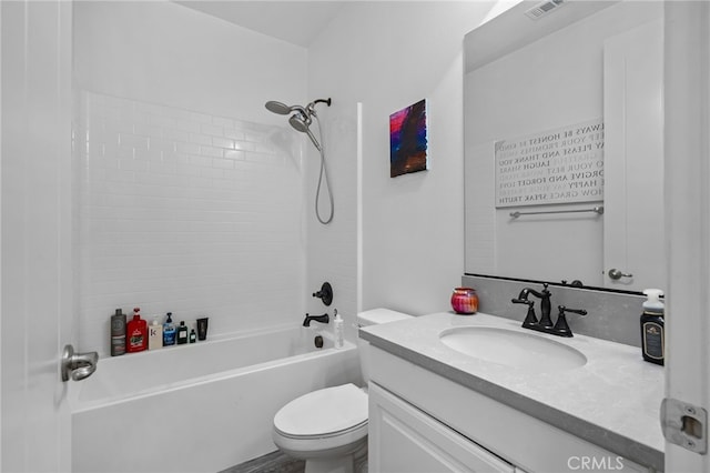 full bathroom featuring tiled shower / bath, vanity, and toilet