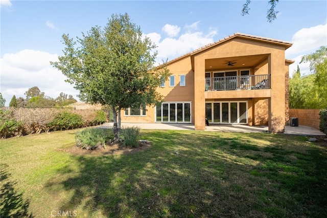 back of house with a balcony, a lawn, ceiling fan, and a patio area