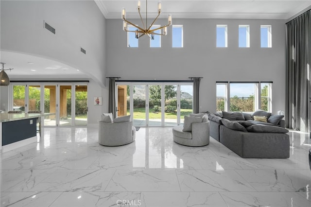 living room with crown molding, french doors, and a chandelier