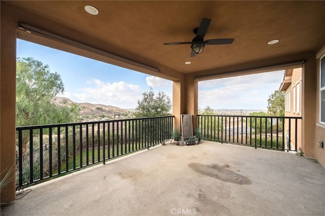 view of patio / terrace with a mountain view, a balcony, and ceiling fan